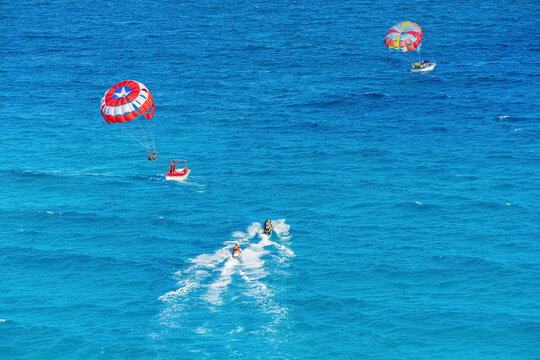 Parasailing towed behind a boat in the Caribbean sea, tropical Ocean, Vacation Concept, Cancun, Mexico