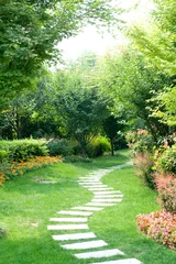 Tuinposter A winding stone road in the villa garden © 泰峰