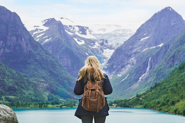 Adventure backpacking woman enjoying view of majestic mountain lake explore travel discover...