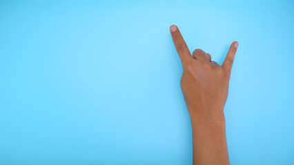 Fototapeta premium Male hand showing hand sign isolated on blue background 