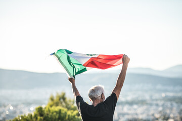 Senior man holding flag of Mexico. 