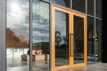 Glass door entrance to a large apartment hotel, the material is wood and steel, beautifully...