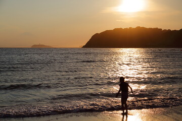 夏休みの思い出、夕暮れの逗子海岸で遊ぶ子どもの後ろ姿