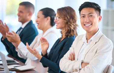 Fototapeta premium Teamwork, motivation and celebration with clapping business people cheering during speech or presentation. Portrait of a happy employee enjoying his career while sitting with diverse team in training
