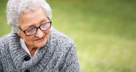 Portrait elderly woman sitting on bench in park smiling looking thoughtful enjoying retirement...