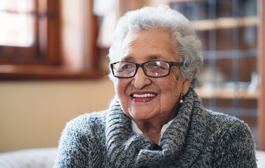 Portrait beautiful elderly woman smiling sitting on sofa at home enjoying retirement - Powered by Adobe