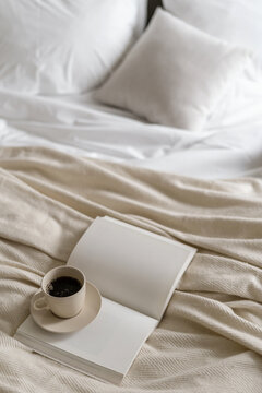 Coffee cup with blank page diary journal on bed