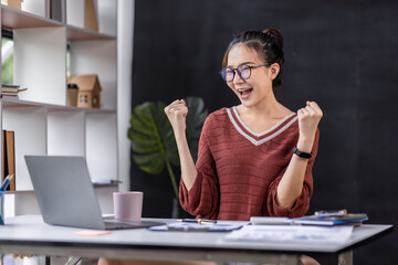 Excited happy freelance asian woman looking at the phone screen, celebrating an online win, overjoyed young asian female screaming with joy, isolated over a white at workspace blur background