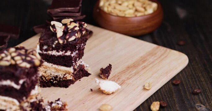 move chocolate cake with nut filling and peanuts, chocolate cake dessert with peanuts on the board