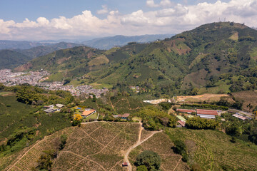 View from a drone of a crop field with a rural village in the background. Colombia.