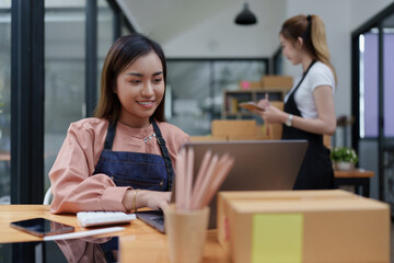 Asian SME business woman with partner working at home office. online shopping concept