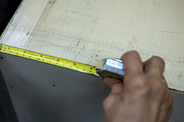 A hand using measuring tape