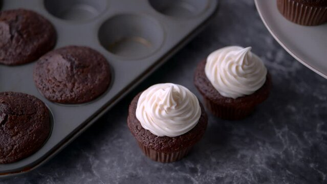 chocolate cupcake with white icing on dark background
