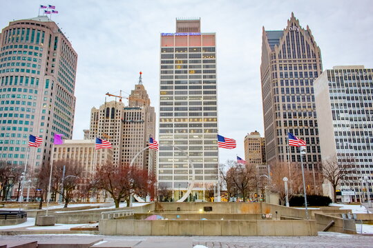 Downtown Detroit Michigan city buildings and American flags at Hart Plaza on a cloudy winter snow day