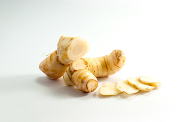 Galangal and sliced galangal on a white background.
