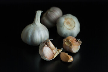 Several heads of garlic put on a black background.