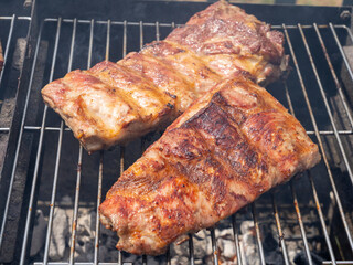 Roasted Juicy spare ribs cooked over the coals on a barbecue. Summer and holiday time. Delicious food