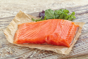 Raw salmon fillet over board