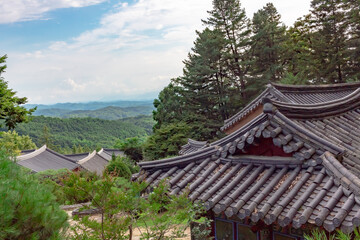 Traditional Korean architecture and lush green forest and mountains at Buseoksa Buddhist temple in South Korea on a cloudy day	