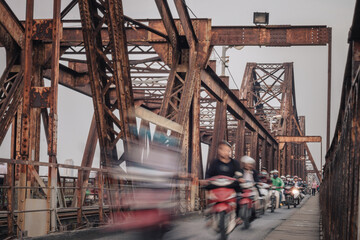 Speed blurred motorbikes on Long Bien Bridge in Hanoi