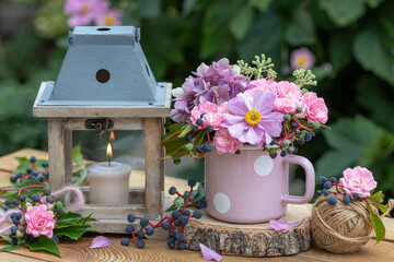 Arrangement mit Blumenstrauß mit Herbst-Anemone, Rosen und Hortensienblüten in Emaille-Tasse und...