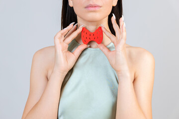 Young asian woman is holding mockup thyroid gland. Help and care concept