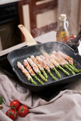 Healthy food - Asparagus wrapped with bacon and spices on grill pan