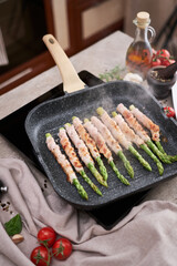 Healthy food - Asparagus wrapped with bacon and spices on grill pan