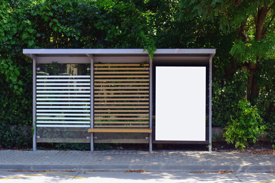 bus shelter at a bus stop. image collage. blank white glass and metal structure. urban setting with green background. safety glass design. white poster ad display. base for mockup. advertising concept