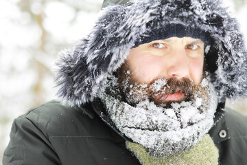 Bearded man in the winter woods. Attractive happy young man with beard walk in the park.