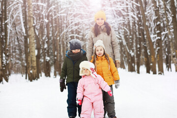 Fototapeta na wymiar Happy family playing and laughing in winter outdoors in the snow. City park winter day.