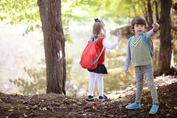 Children with briefcases for a walk in the park. School break. The beginning of the children's studies.