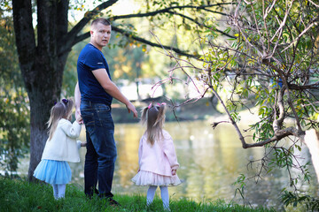 Fototapeta premium Leaf fall in the park. Children for a walk in the autumn park. Family. Fall. Happiness.