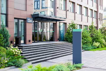 Entrance in business center in  city. Modern Business Center with a green park with benches and fountains