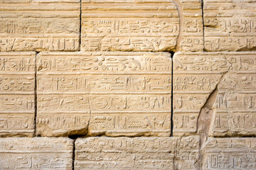 Ancient frescoes, hieroglyphs, images, symbols and of Egyptian gods on the wall of Karnak Temple complex (ancient Thebes). Luxor, Egypt. Copy space. Selective focus. - Powered by Adobe