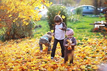 Fototapeta premium Young family on a walk in the autumn park on a sunny day. Happiness to be together.