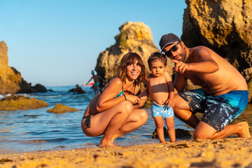A family on the beach with their son at Praia dos Arrifes, Algarve beach, Albufeira. Portugal