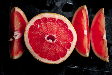 sliced red grapefruit on black background