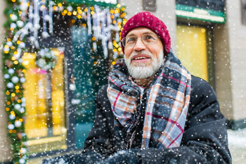 trendy old good-looking man walking in sity street at winter near modern building