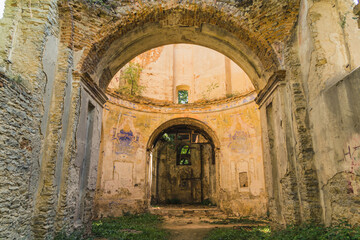 Fototapeta na wymiar Damaged archway entrance to abandoned church. Old weathered structure. Christian architecture. Lubycza Krolewska. Horizontal shot. High quality photo