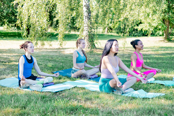 four young women group diverse people asian woman, mixed race female, woman with bionic prosthetic leg do sport yoga morning mats outside in park, healthy lifestyle, fitness, training and stretching