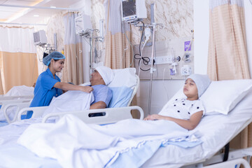 Smiling nurse covering male patient on bed with blanket at hospital ward 
