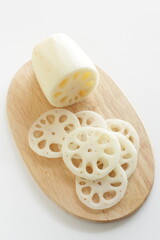 Sliced lotus roots on wooden chopping board with copy space