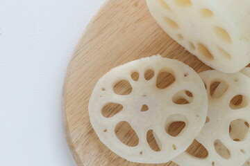 Sliced lotus roots on wooden chopping board with copy space