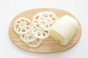 Sliced lotus roots on wooden chopping board with copy space