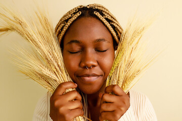 African american woman with braids and wheat plants