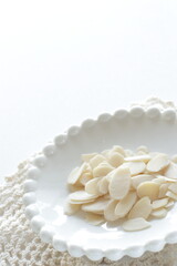 Sliced almond on white dish with copy space 
