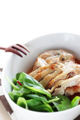 Asian food, grilled chicken served with soy sauce and baby leaf salad