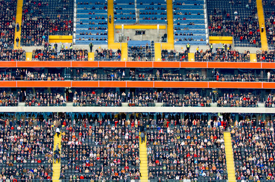 Viele Menschen verfolgen ein Fu&szlig;ballspiel auf der Trib&uuml;ne eines Stadions in einer Teleaufnahme