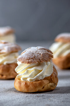 Homemade profiteroles with cream on light background
